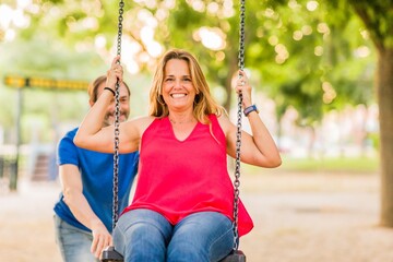 married mature 50s couple enjoy happy in playground swing. Seniors freedom love and happiness
