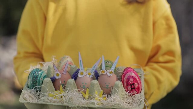 Girl keeps decorated Easter eggs in the palms