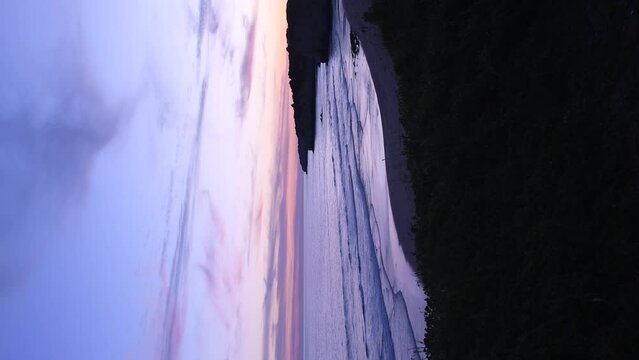 Vertical video of sunset at the Atlantic Ocean in Armacao de Pera. 4K video of beach in the Algarve.