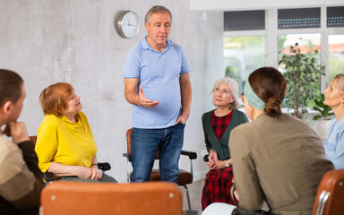 Man tells an interesting story. Retirees listen carefully