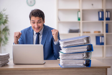 Young male employee and too much work in the office