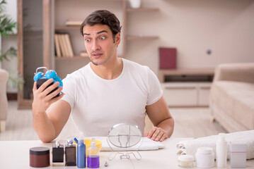 Young man shaving face at home