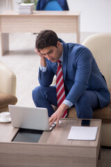 Young male employee sitting in the office