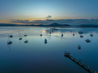 Soft and hazy aerial sunrise waterscape with boats