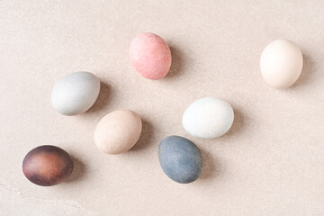 Natural dyed Easter eggs on beige table. Eco, pastel pale colors.