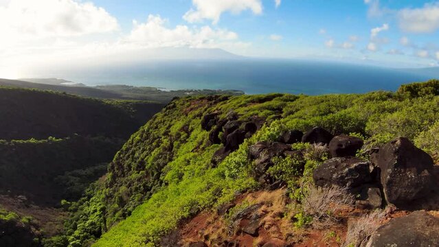 FPV aerial photo shows breathtaking green mountains scenery and amazing blue ocean nearby. Explore Hawaii green mountains, waterfalls and hiking trails in a sustainable ecotourism paradise.