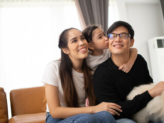 family mother father son girl kid child happy pretty hug group parent female male love holiday vacation funny enjoy sofa house home living room together family laugh relaxation beautiful copy space 