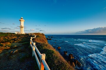 Lighthouse and seascape at sunrise time - obrazy, fototapety, plakaty