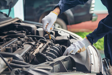 Fototapeta premium Close up Car Mechanic man hands repairing car auto repair shop. Man hands fixing machinery vehicle mechanical service. open vehicle hood checking up auto mobile. Vehicle Car maintenance engineer.