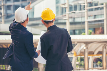 Two men engineer look at blueprint architecture building contractor design in modern city development. Males engineer holding project planing partner teamwork. Man meeting together construction site