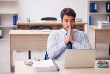 Naklejka premium Young male employee working in the office
