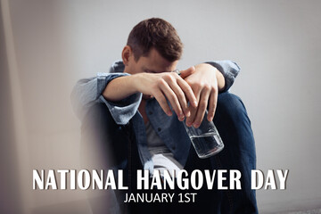 National hangover day - January 1st. Man with bottle of alcohol near wall