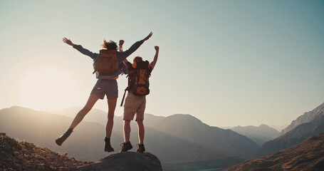 Travel concept with happy couple at mountain top with raised arms and islands at background. Place for text.  - obrazy, fototapety, plakaty