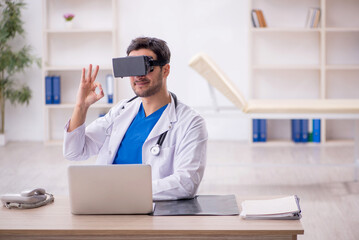 Young male doctor enjoying virtual glasses in the clinic