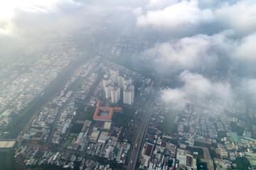 Aerial view of Saigon cityscape at morning with misty sky in Southern Vietnam. Urban development texture, transport infrastructure and green parks