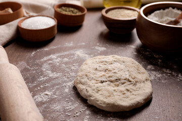 Fresh dough and rolling pin on wooden table. Cooking grissini