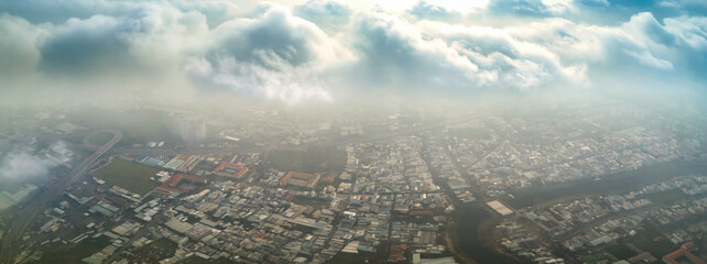 Aerial view of Saigon cityscape at morning with misty sky in Southern Vietnam. Urban development texture, transport infrastructure and green parks