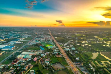 Poster Aerial view of Saigon cityscape at evening with sunset sky in Southern Vietnam. Urban development texture, transport infrastructure and green parks © huythoai