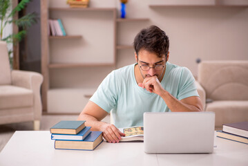 Fototapeta premium Young male student preparing for exams at home