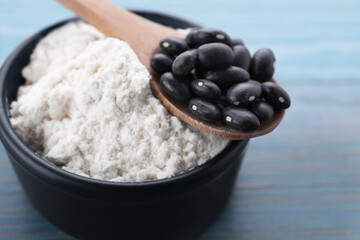Kidney bean flour and black seeds on light blue wooden table, closeup
