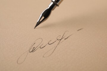 Signature and fountain pen on sheet of paper, closeup