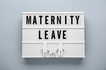 Lightbox with words Maternity Leave and figures of family on light grey background, top view