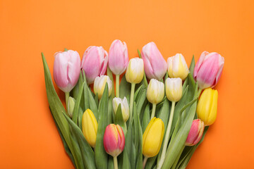 Beautiful colorful tulips on orange background, flat lay