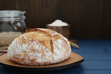 Freshly baked bread on blue wooden table. Space for text