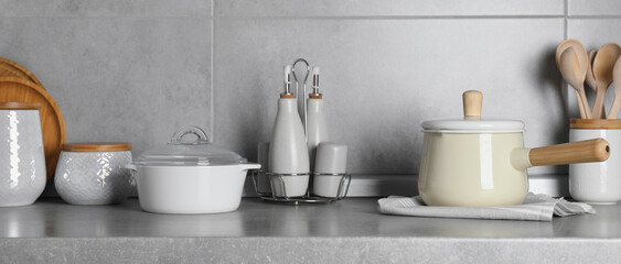 Fototapeta na wymiar Set of different cooking utensils on grey countertop in kitchen, banner design