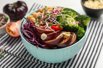 Delicious vegan bowl with broccoli, red cabbage and black tomato on table, closeup