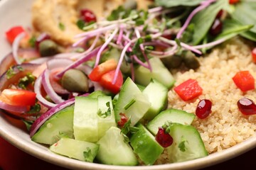 Delicious vegan bowl with cucumbers, spinach and bulgur, closeup