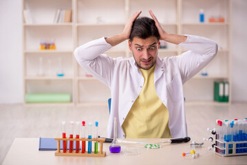 Young male chemist sitting at the lab