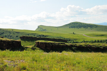 Wide gaps in the walls of the ancient sanctuary going along the tops of a gentle hill on a clear summer morning.