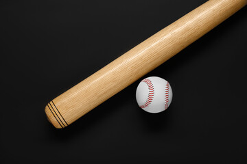 Wooden baseball bat and ball on black background, flat lay. Sports equipment