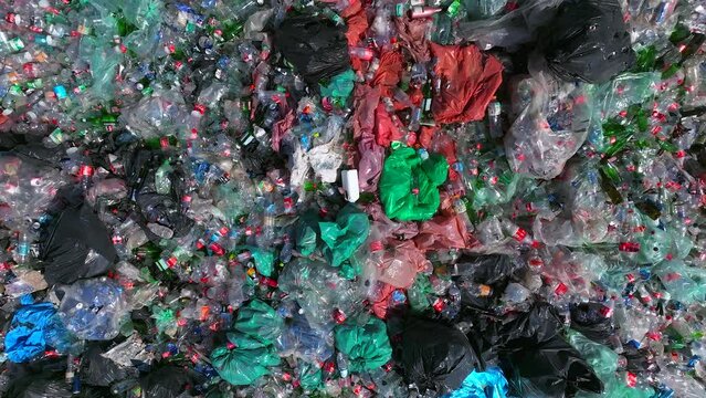 Plastic bottles and Trash Soda cans recycling piles in a local facility, Top down view