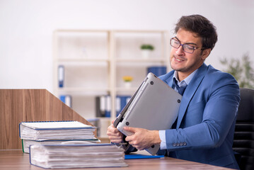 Young male employee and too much work in the office