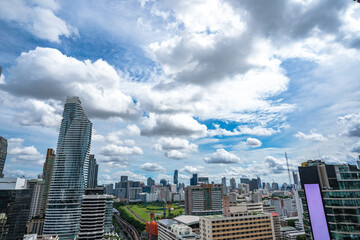 Bangkok Aerial Skyline and Skytrain view of Thailand. Business and financial building area centers with smart green park among urban city at noon time.
