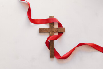 Cross with a red ribbon, a symbol of Christ. Crucifixion Of Jesus Christ. Passion Of Jesus Christ. Concept for faith, spirituality and religion. Easter Day