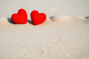 Fototapeta na wymiar red hearts on tropical beach on sunny day with free copy space for text