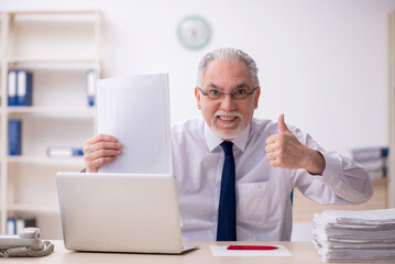 Old male employee working in the office