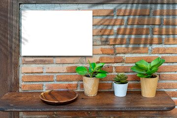 A white sign on a red brick wall is installed at the entrance of a restaurant or cafe. The shadow of the leaves on the wall