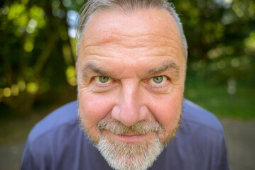 Smiling middle aged man leaning in towards the camera