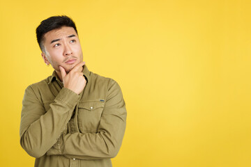 Chinese man with hand on face and thoughtful expression