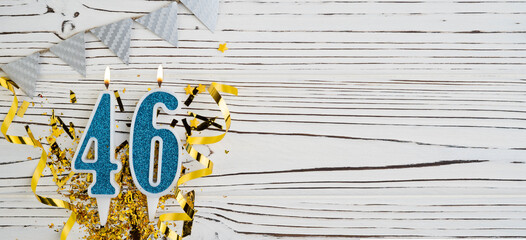 Number 46 blue celebration candle on white wooden background. Happy birthday candles. Concept of celebrating birthday, anniversary, important date, holiday. Copy space.