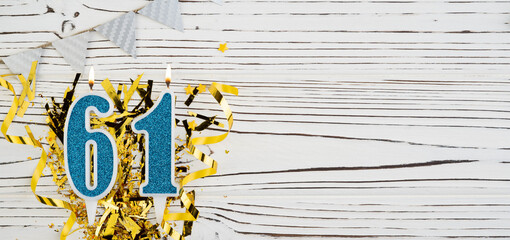 Number 61 blue celebration candle on white wooden background. Happy birthday candles. Concept of celebrating birthday, anniversary, important date, holiday. Copy space.