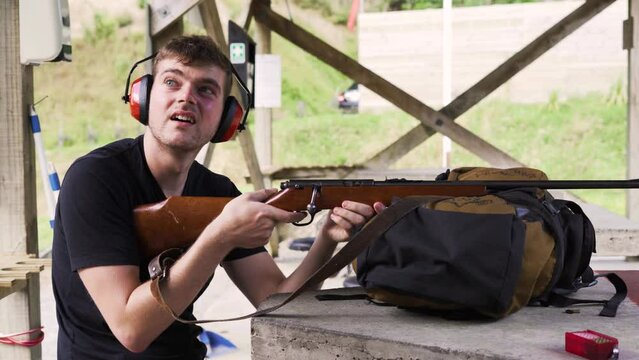 Caucasian Guy Trained To Fire A Rifle On A Shooting Range. Close Up