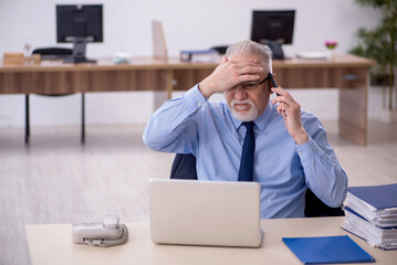 Fototapeta premium Old male employee working in the office
