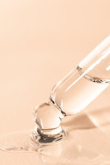Beauty background with pipette and liquid care product. Dropper with serum, soap, hyaluron on a beige background.