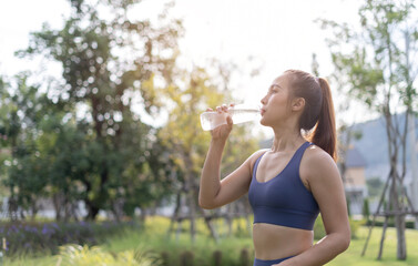 Woman drinking clean water from bottle. Woman workout drink water after running. Female drinking water after exercise or sport. Athlete woman relax and drinking water after workout.