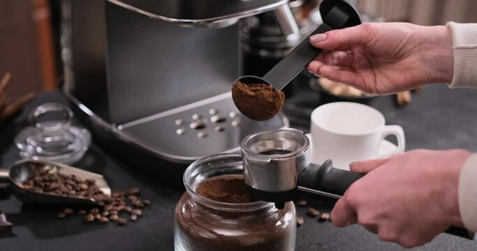 Woman Making Ground Coffee with Tamping fresh coffee into portafilter